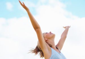 A woman with her arms up in the air.