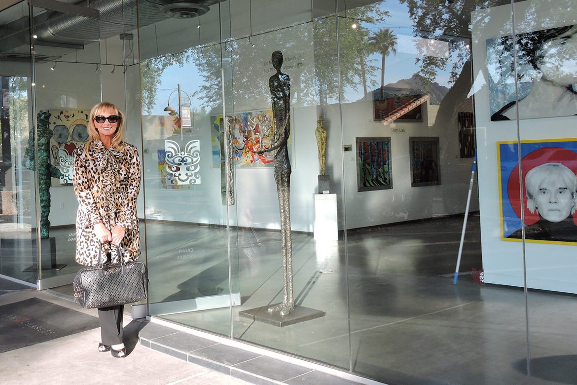 A woman standing in front of an art gallery.