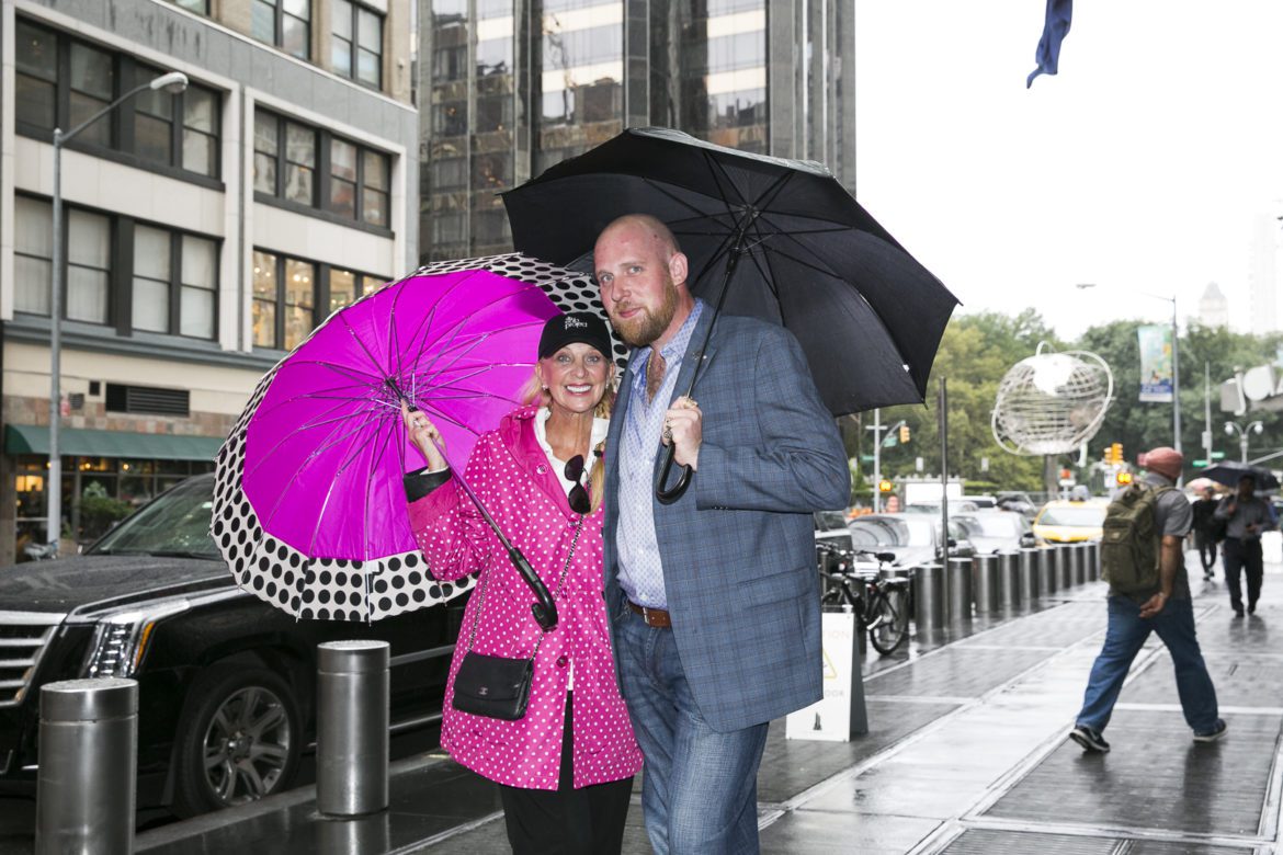 A man and woman holding umbrellas on the sidewalk.
